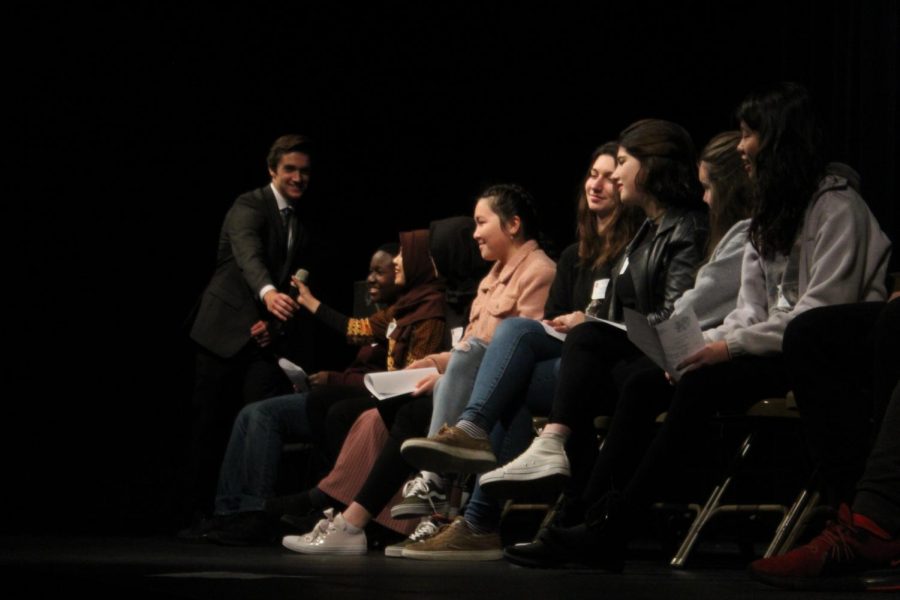 Ifada Auzan hands back the microphone to an Xavier student senate member after answering a question.