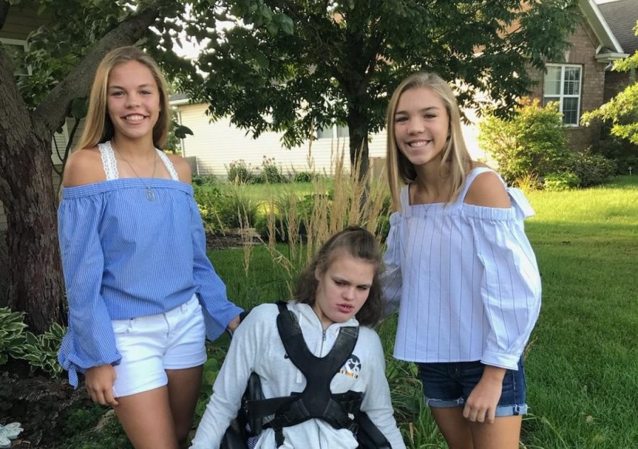 Gabbie, Maddie, and Carlie Schroeder pose in the outdoors, all wearing blue and white.
