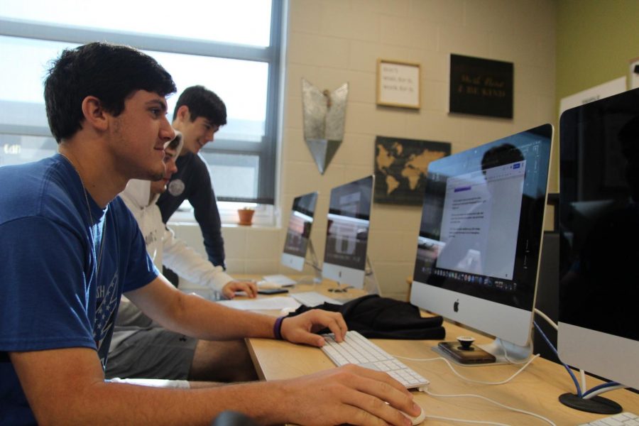 Zack Anderson, Max Tafolla and Brody Fishman working in newspaper.