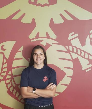 Miranda Jones, senior, poses in front of the Marines logo. She plans  to finish school early and leave Feb. 16.