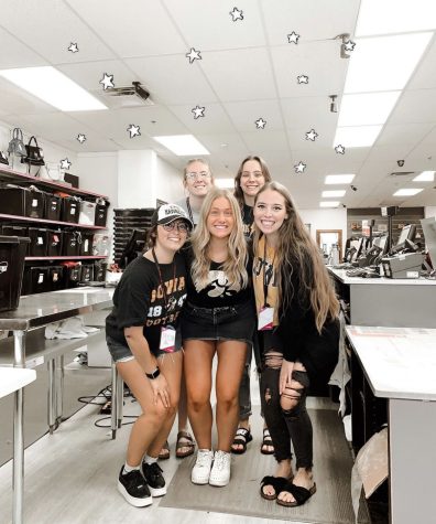 Emma Johnson posing with co-workers at her job, Platos Closet.