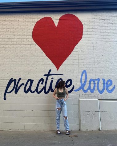 Rosie Terry, sophomore, posing in front of a graffiti wall.