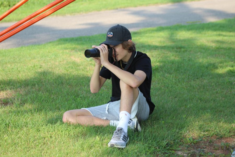 Yearbook staff member James Frantz, junior, taking photos at a sporting event.