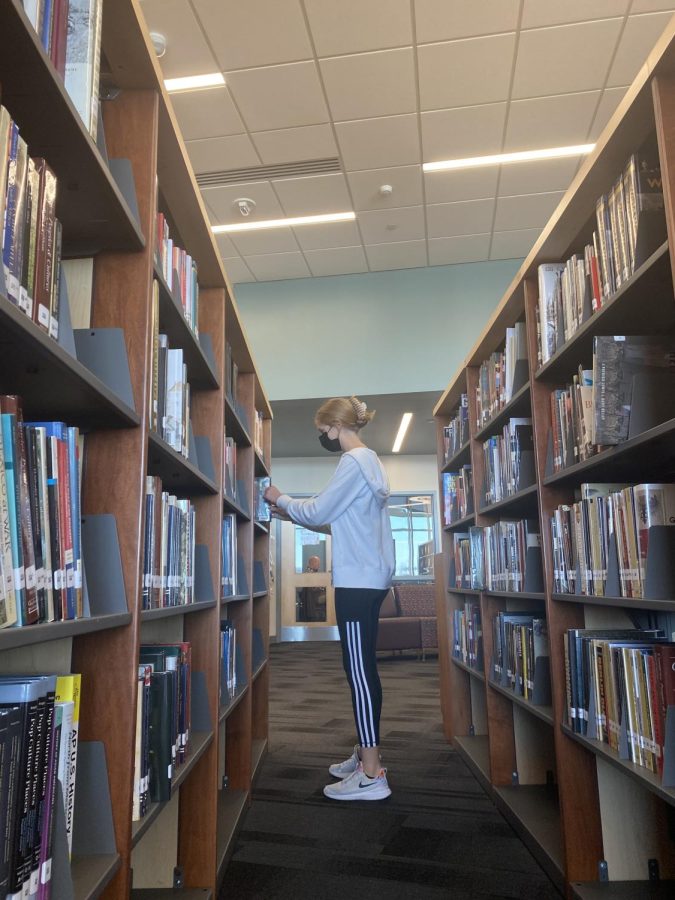 Ella Gilbert, sophomore, searching for a book to check out from the library.