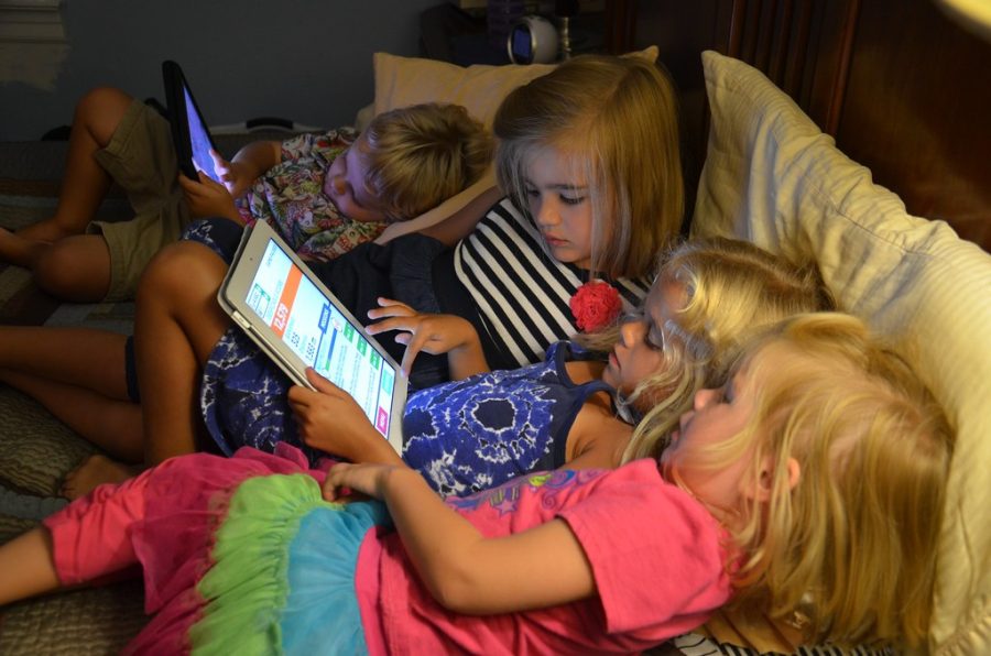 Four kids playing on Ipads with each other. (Creative Commons Image)