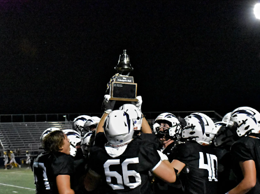 Lightning players gather in a huddle after the football game celebrating their win and “The Principal’s Bell” trophy. 