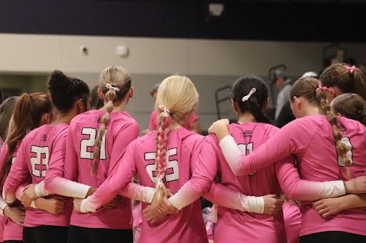 The Liberty volleyball team huddles together to talk with their captains about the next play.